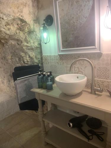 a bathroom with a white sink and a mirror at Les Troglos de la Tufolière in Rochecorbon