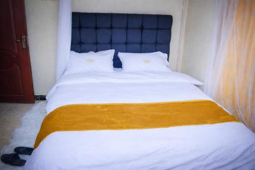 a bedroom with a large bed with a blue headboard at Zariah Homes 1BR Ksm in Kisumu