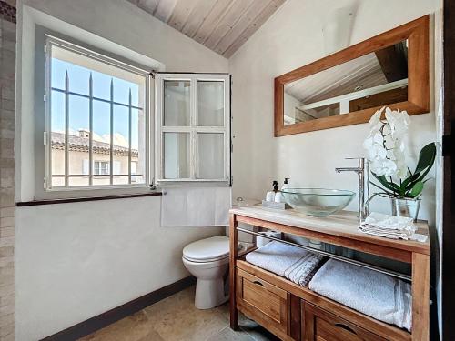 a bathroom with a sink and a toilet and a window at Clos des Cassis - Maison d'Hôtes in Villeneuve
