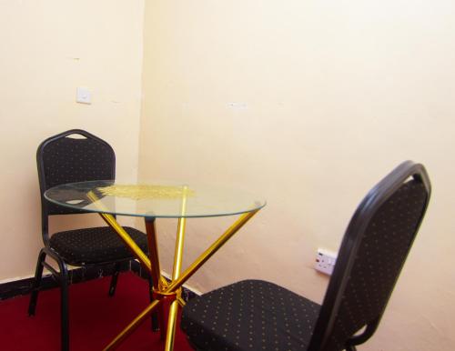 two chairs and a glass table in a room at Zariah Homes 1BR Ksm in Kisumu