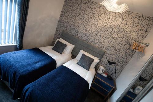 two beds in a hotel room next to each other at Cherish Lewis Hotel Blackpool- 2 min to Beach- Smart Lock- Fast WiFi in Blackpool