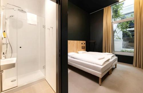 a bedroom with a bed and a shower and a sink at JO&JOE Vienna in Vienna