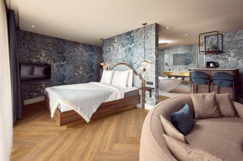a bedroom with a bed and a couch at Van der Valk Hotel Melle - Osnabrück in Melle