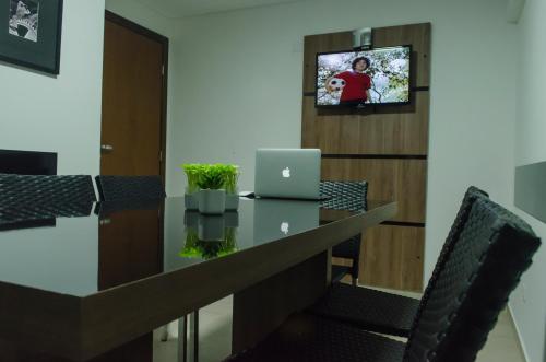 an office with a desk with a laptop on it at Hollyster Hotel in Curitiba
