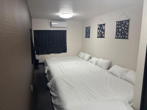 a room with two large white beds in it at HOTTOSTAYHoNMACHI in Nagoya