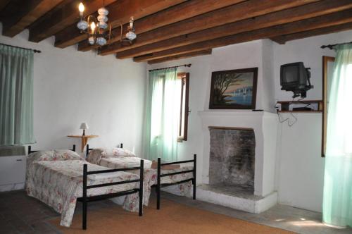 a bedroom with two beds and a fireplace at Cá Scirocco in Ca Grignella