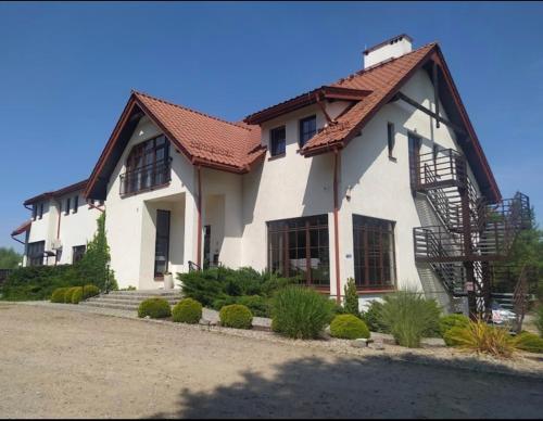 a white house with a red roof at Siedlisko Nielbark in Nielbark