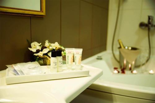 a bathroom sink with toiletries and a vase of flowers at Hotel Metsis in Valga