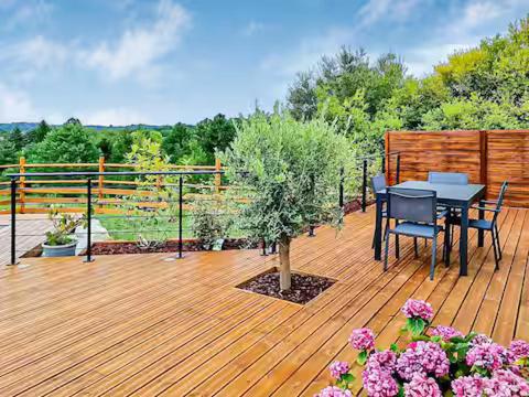 une terrasse avec une table et des chaises sur une terrasse en bois dans l'établissement Newlook 2, à Trélissac