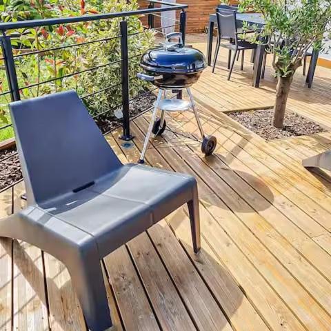 un barbecue et une chaise sur une terrasse dans l'établissement Newlook 2, à Trélissac
