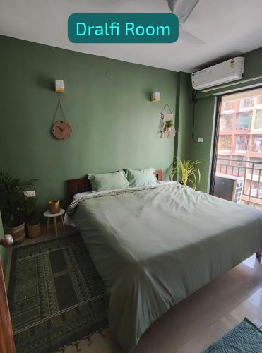 a bedroom with a bed and a green wall at Blue Door Homes in Navi Mumbai