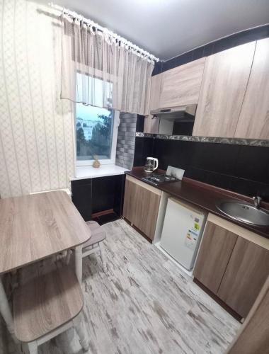 a small kitchen with a table and a sink at Уют in Kropyvnytskyi