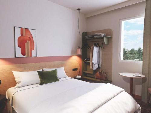 a bedroom with a large white bed and a window at All Suites Hôtel Chartres Centre Gare in Chartres