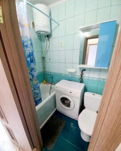 a bathroom with a toilet and a washing machine at Уют in Kropyvnytskyi