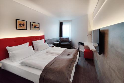 a hotel room with a bed and a tv at Garner Hotel Wiesbaden City by IHG in Wiesbaden