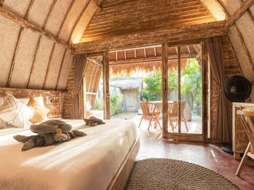 a teddy bear laying on a bed in a room at Private Pool Romantic Villa - Adults Only - VILLA PALMA - Gili Meno in Gili Meno