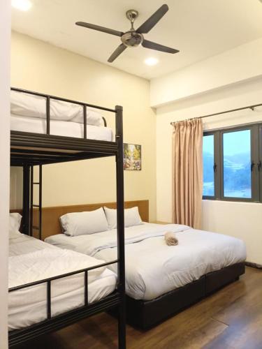 two bunk beds in a room with a ceiling fan at Bayt Rizq Homestay 3R2B in Brinchang