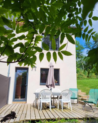 a deck with a table and chairs and a cat on it at Gîte Volcans - 1-4 pers, au calme à 20 mins de Vulcania, Puy-de-Dôme et Lemptegy, 35 mins du Mont Dore et du Sancy in Gelles