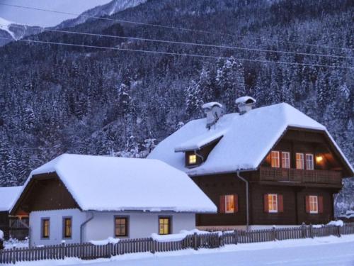 a house covered in snow in front of a mountain at Ferienhaus Almenblick in Fellbach