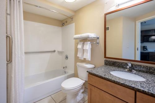 a bathroom with a toilet and a sink and a shower at Candlewood Suites Windsor Locks by IHG in Windsor Locks