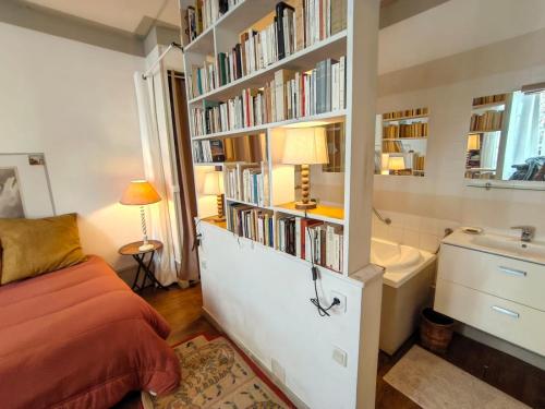 a bedroom with a bed and a book shelf with books at Maison Romane 1136 in Cluny