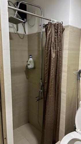 a shower with a shower curtain in a bathroom at Haven's Suites a place like home in Manila