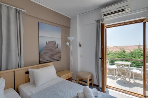 a bedroom with a bed and a balcony at Olive Press Hotel in Mythimna