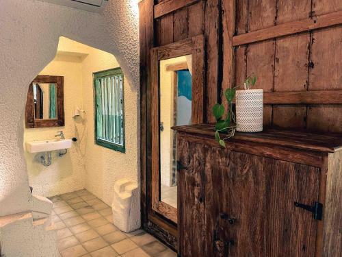 a bathroom with a wooden door and a sink at Omahe Kancaku in Balong
