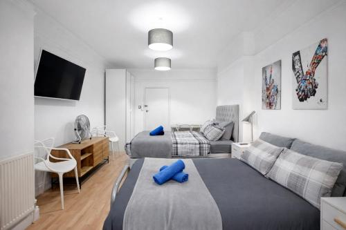 a bedroom with two beds and a couch at Large Studio Garden Flat on Golders Green Road in London