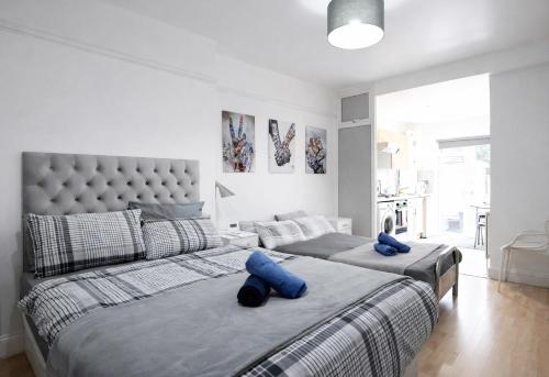 a bedroom with two beds with blue pillows on them at Large Studio Garden Flat on Golders Green Road in London