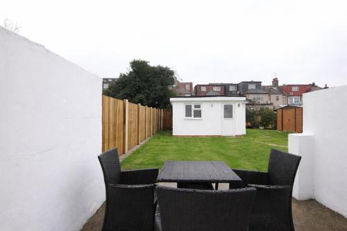 a patio with a table and chairs in a backyard at Large Studio Garden Flat on Golders Green Road in London