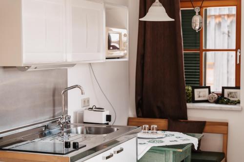 a kitchen with white cabinets and a sink at Kultur Weingut Kästenburg in Ratsch an der Weinstraße