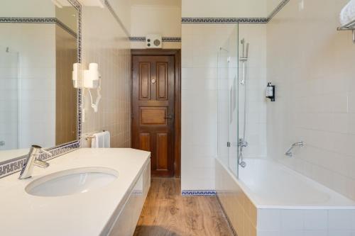 a bathroom with a sink and a shower and a tub at Pousada Castelo de Palmela in Palmela