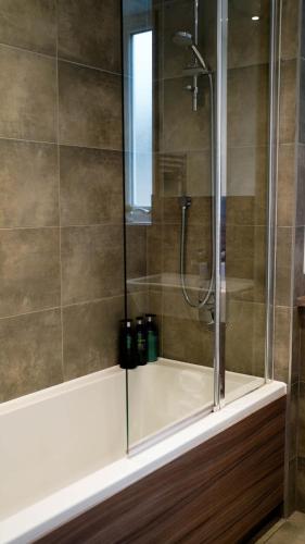 a bathroom with a shower with a glass door at Beautiful Flat 2-Mins away from Rochester Station in Rochester