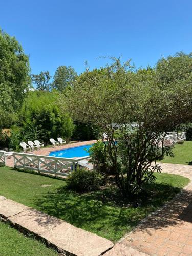 a tree in front of a swimming pool at Hotel Prater in Villa General Belgrano