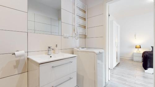 a white bathroom with a sink and a washing machine at Studio Fibra Lungo in Rybnik