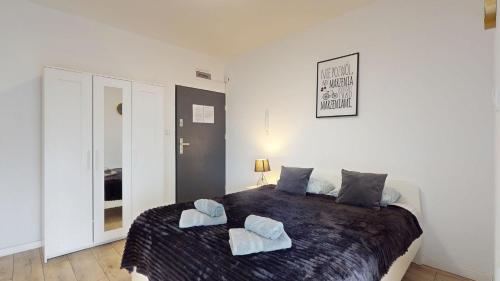 a bedroom with a large bed with two towels on it at Studio Fibra Lungo in Rybnik