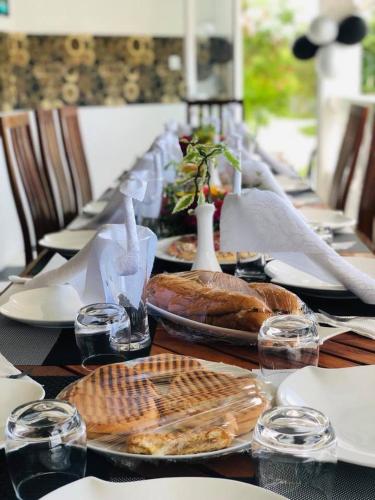 a long table with plates of food and wine glasses at Newsy Inn in Hithadhoo