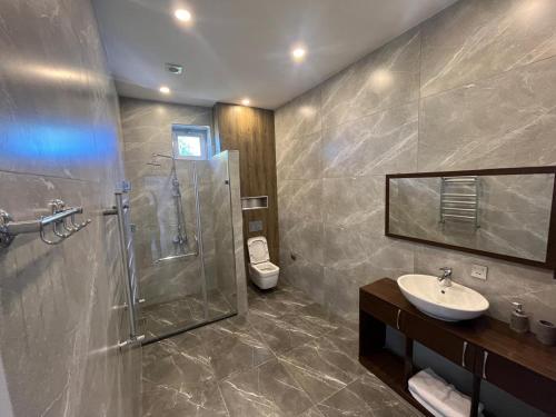a bathroom with a shower and a sink and a toilet at Lanai Villas Beach Side in Baku