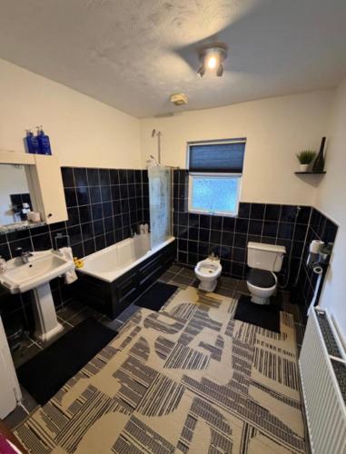 a bathroom with a toilet and a tub and a sink at Rotherham Meadowhall in Rotherham