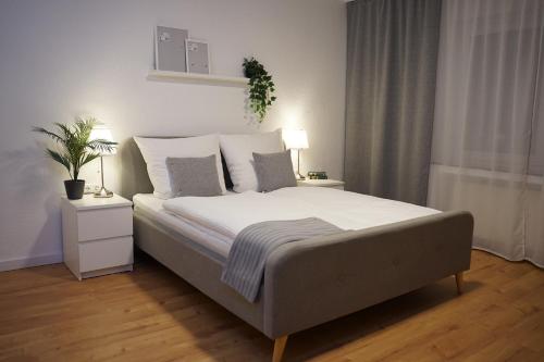 a bedroom with a large bed with white sheets and pillows at HANOSAN Apartments Familienhaus 4 Zimmer 125 m2 in Garbsen