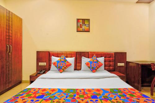 a bedroom with a large bed with a colorful comforter at FabHotel Smart Inn-1 in Gurgaon