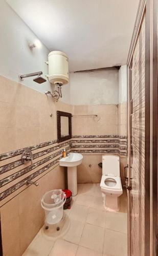 a bathroom with a toilet and a sink at OLT Hostel Rishikesh in Rishīkesh