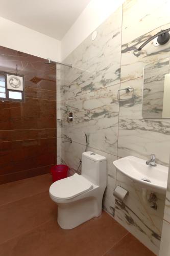 a bathroom with a toilet and a sink at Coastal Calm Inn in Fort Kochi
