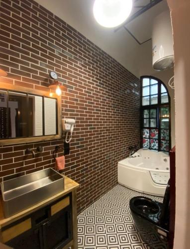 a bathroom with a sink and a bath tub at La Villa Saint Jean in Cotonou