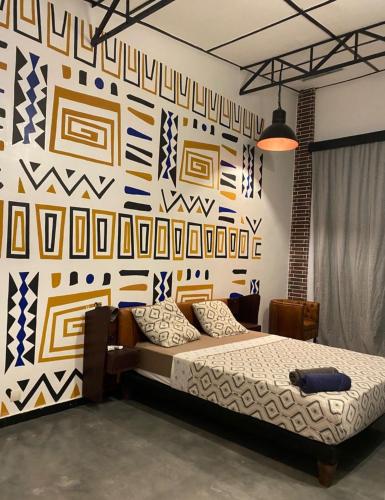 a bedroom with a bed and a wall with patterns at La Villa Saint Jean in Cotonou