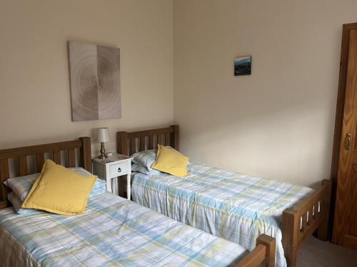 two beds sitting next to each other in a room at Hopeman Cottage in Hopeman