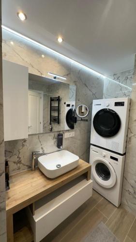 a bathroom with a sink and a washing machine at Apartaments Platja d’Aro in Platja d'Aro