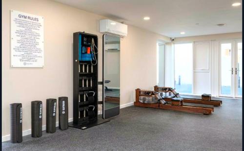 a room with a gym with a rack of wine bottles at 2-Bedroom Modern apt with Gym, roof terrace, Free Parking and 3 min walk to train st in Hersham