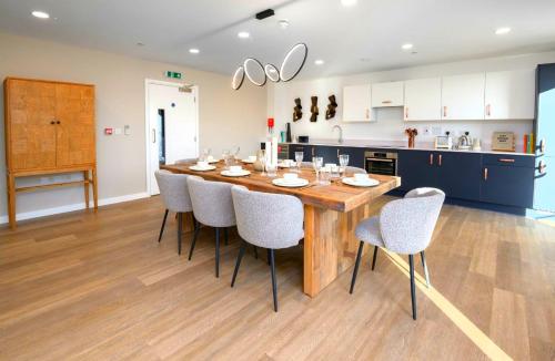 a kitchen with a large wooden table and chairs at 2-Bedroom Modern apt with Gym, roof terrace, Free Parking and 3 min walk to train st in Hersham